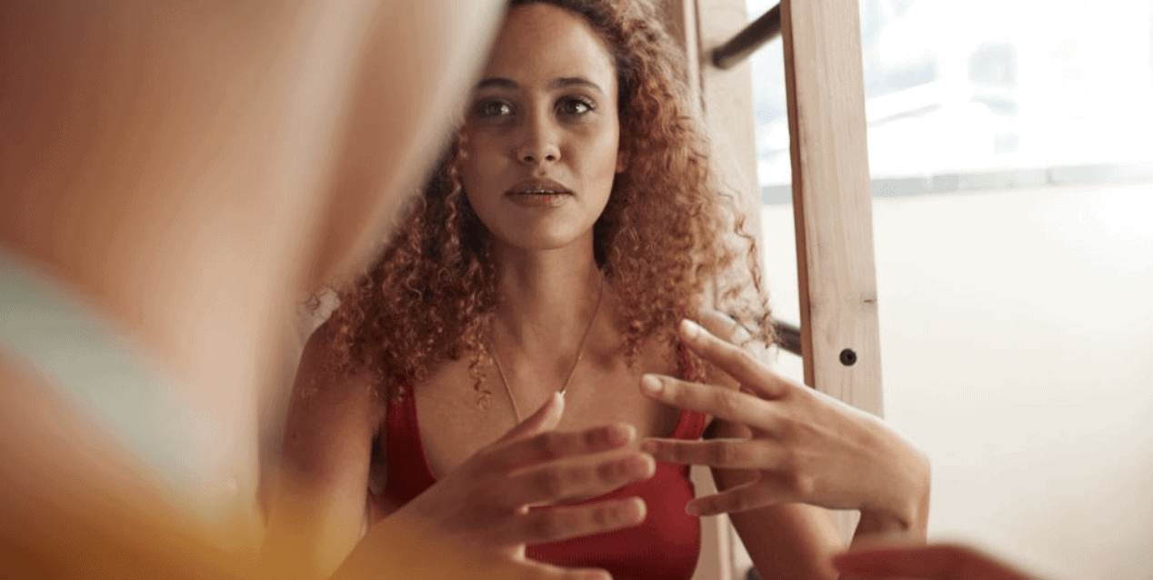 beautiful woman with curly hair talking and gesturing with her hands