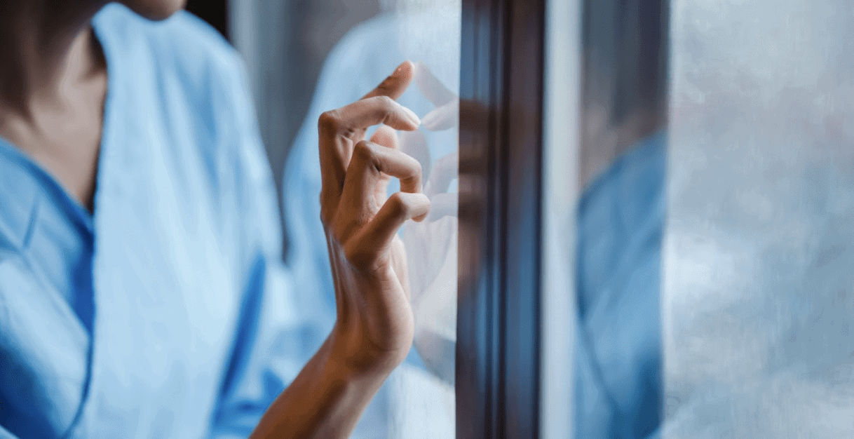 nurse-standing-with-hand-on-window